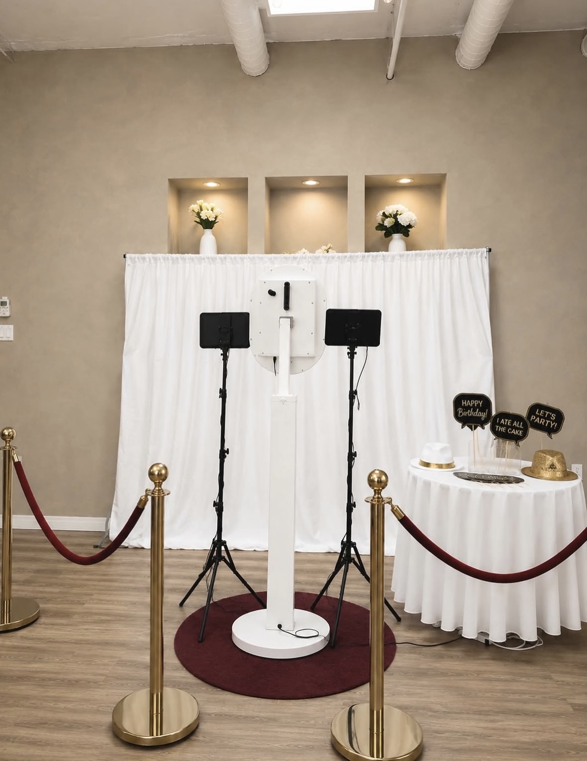 Elegant photobooth setup with a white backdrop and photo props