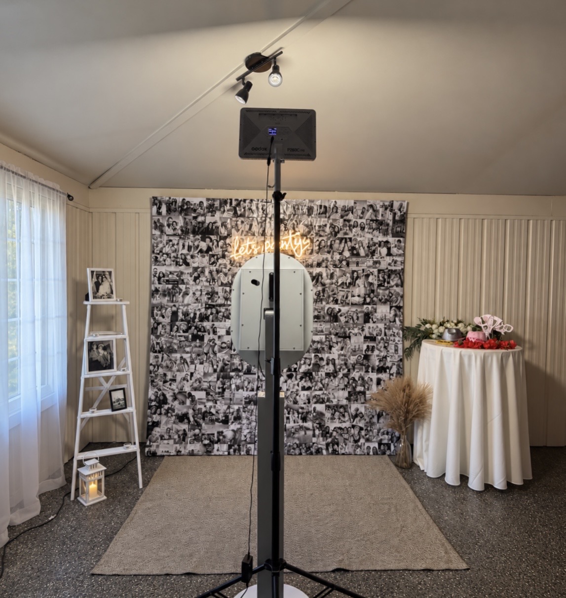 Photobooth setup in front of a black-and-white collage backdrop