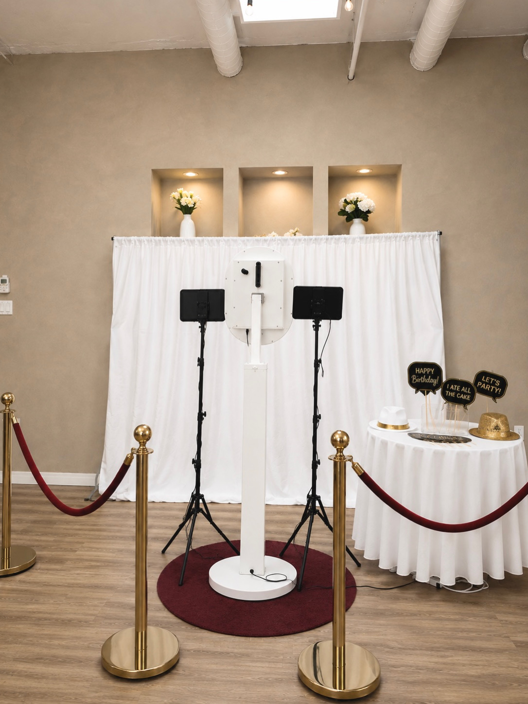 Photobooth setup with a white curtain, lighting and velvet rope stanchions