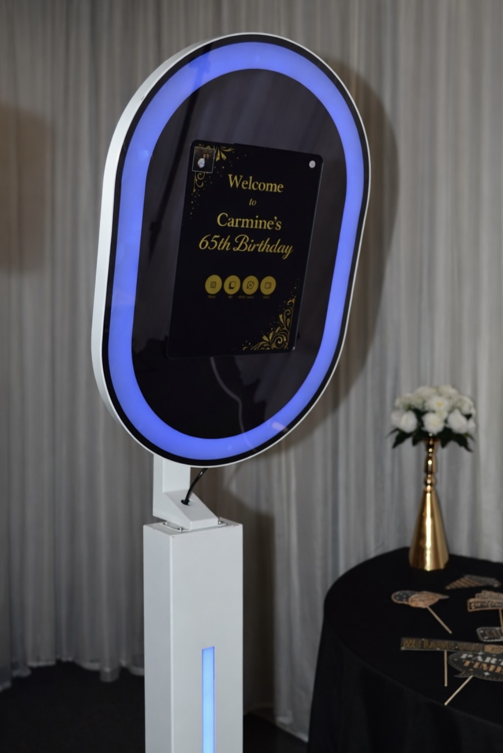 Round mirror photobooth with an illuminated screen and welcome message